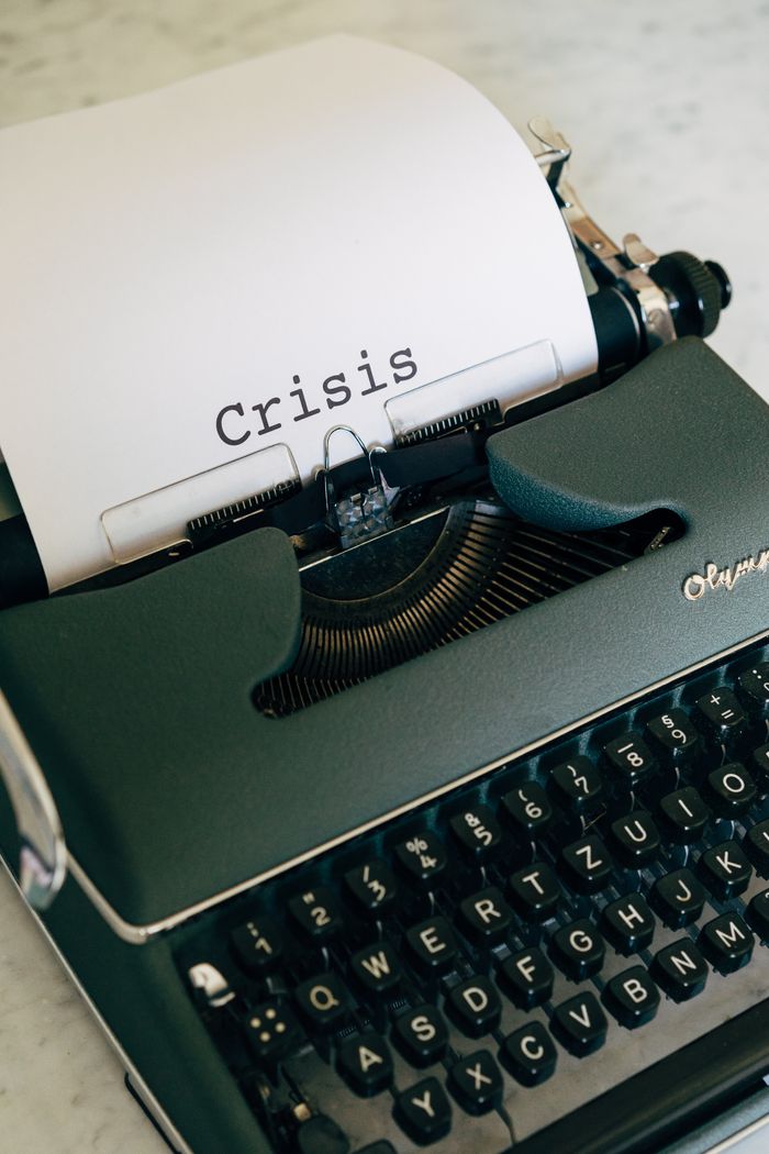 about-us-01 Close-up of a vintage typewriter with the word Crisis typed on paper.
